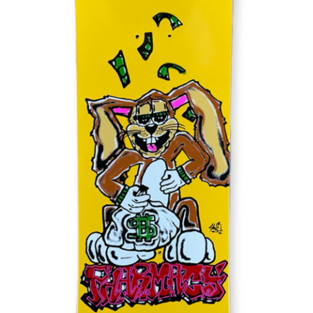 Close up of yellow skateboard deck with cartoon bunny character. Red Pharmacy graffiti style text below.